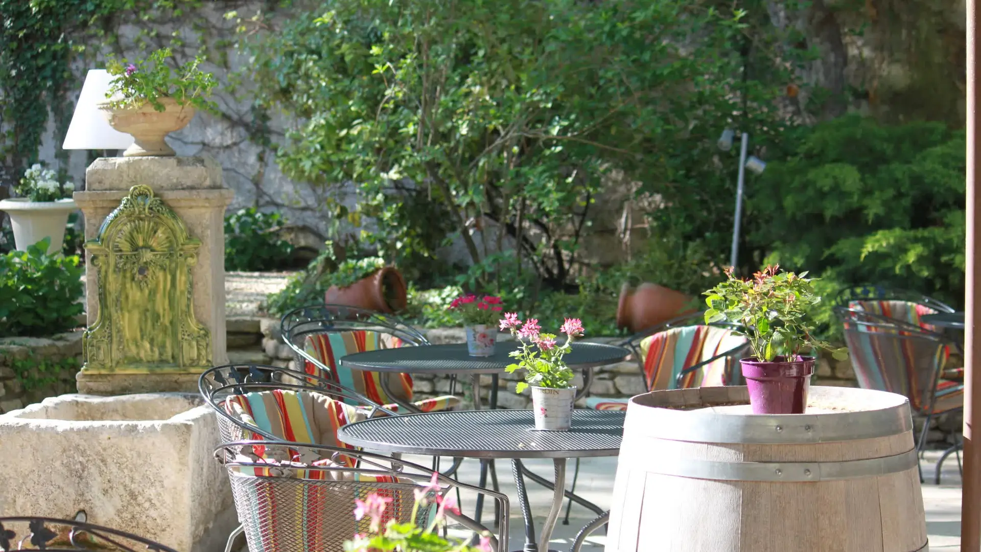Une terrasse fleurie et conviviale, décorée de fer forgé et de touches provençales.