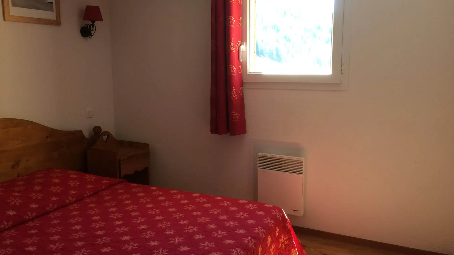 Bedroom with double bed, wooden furniture, window