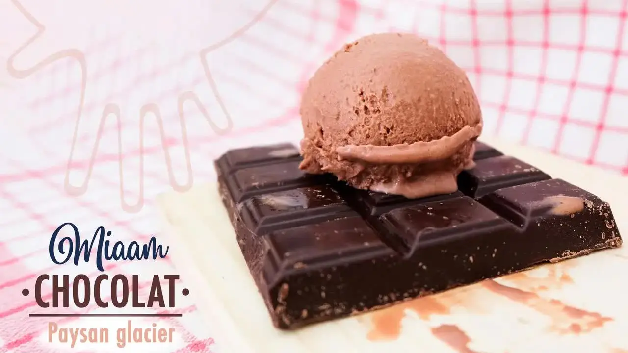 Une boule de glace chocolat posée sur une tablette de chocolat.