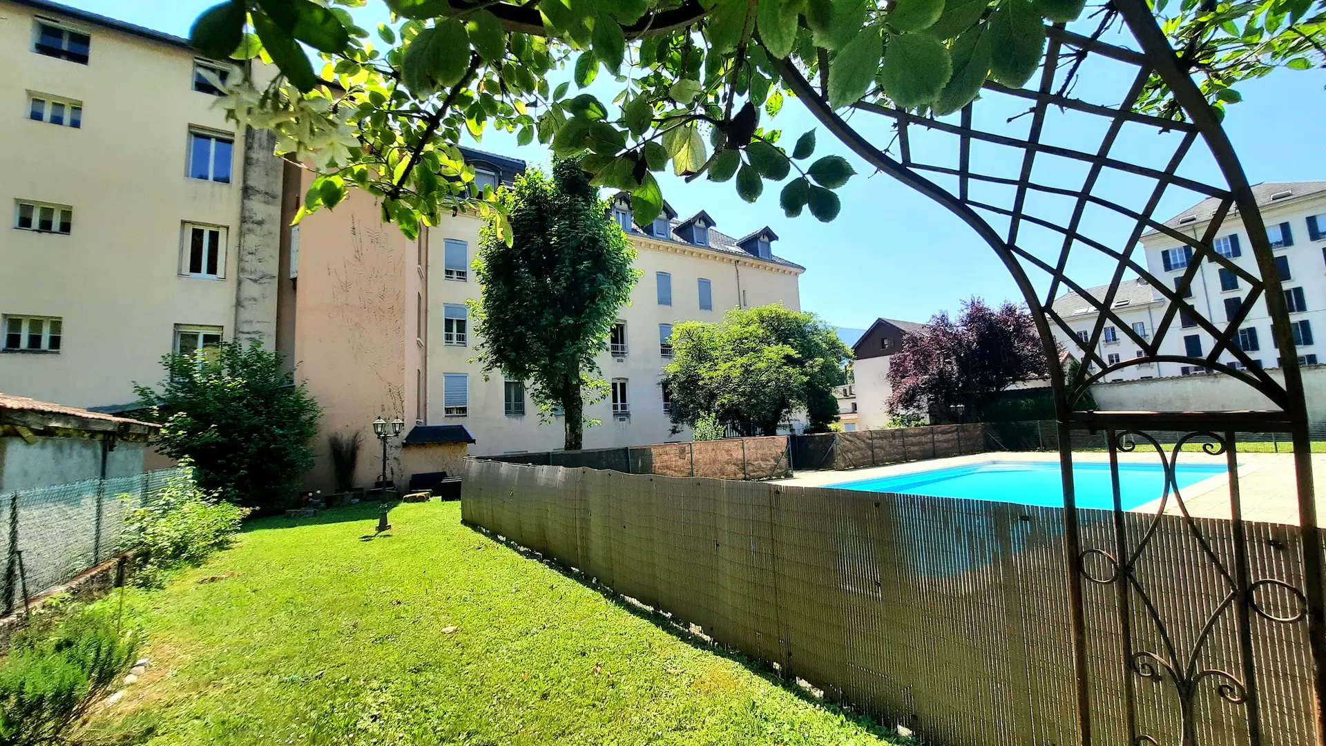 Ce jardin est un espace vert clos, avec une piscine et une pelouse.