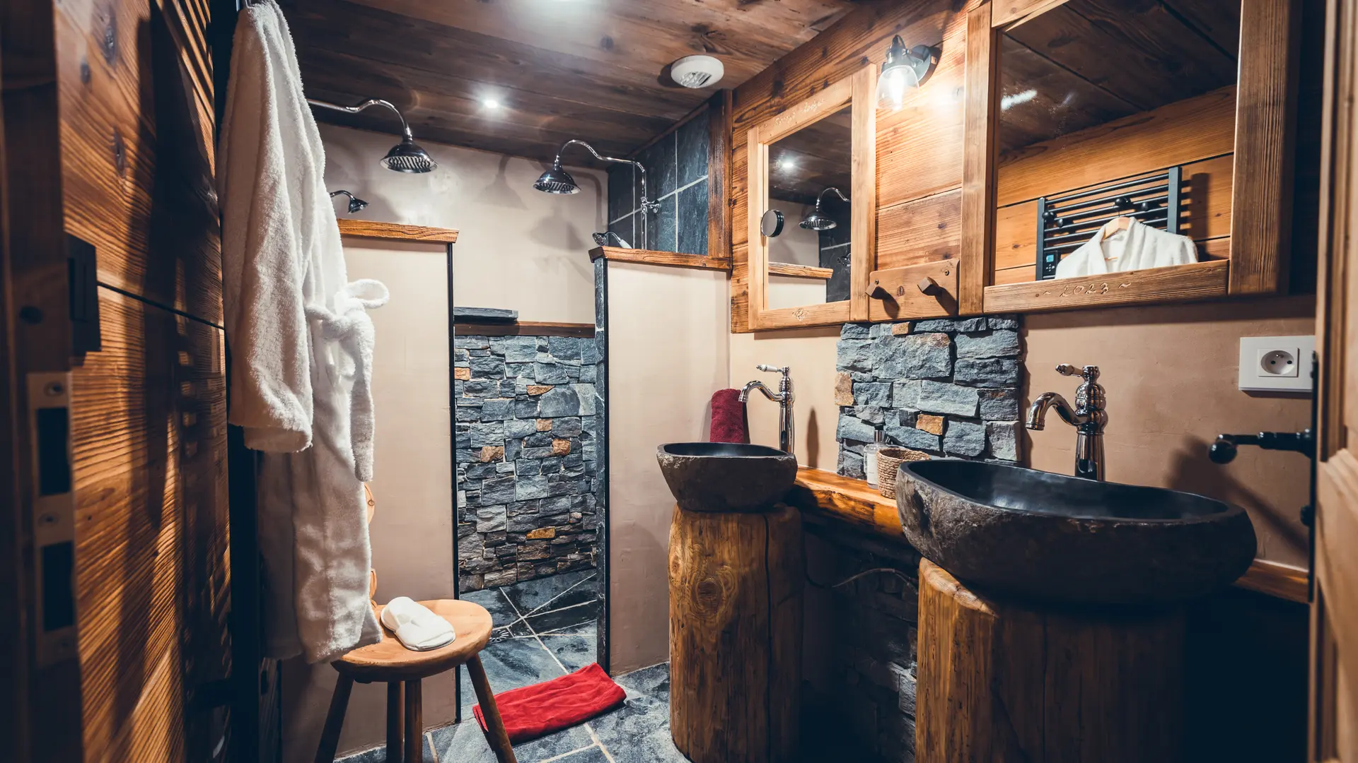 Salle de bains avec double vasque et double douche, décoration pierres et bois