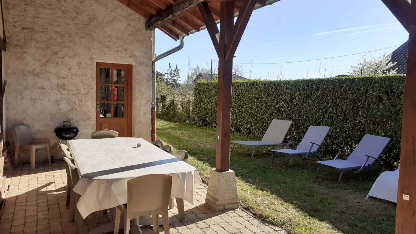 Terrasse couverte à l'arrière de la maison donnant sur un jardin clos - Espace repas (10 couverts)