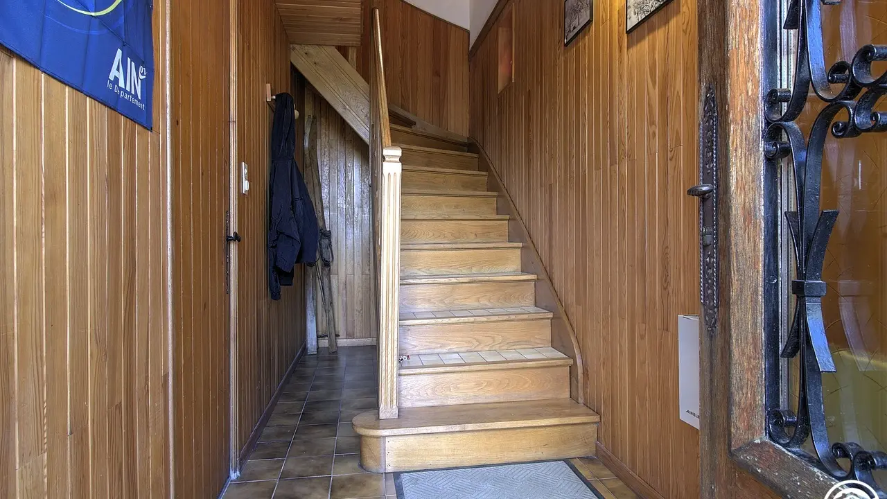Le hall d'entrée au rez-de-chaussée avec à gauche l'accès au garage et l'escalier pour accéder au gîte