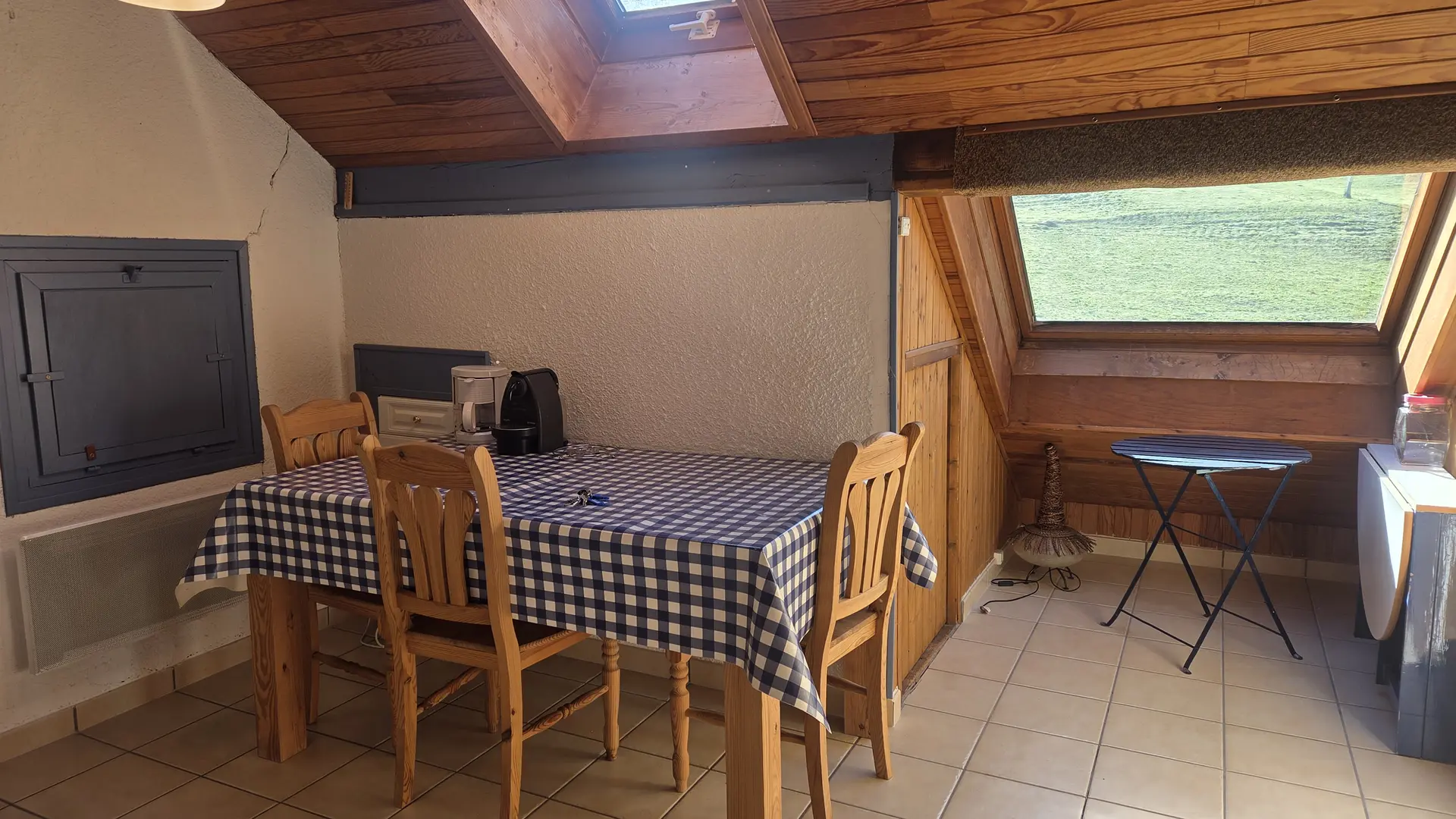 table à manger et chaises en bois, espace lumineux sous un velux