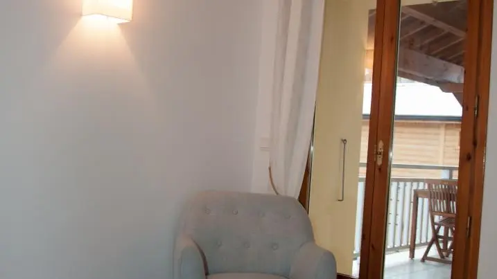 Chambre 2 avec vue sur porte fenêtre donnant sur la terrasse abritée.