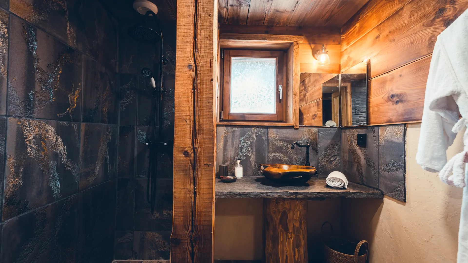 Salle bains avec douche, vasque, décoration bois et pierres