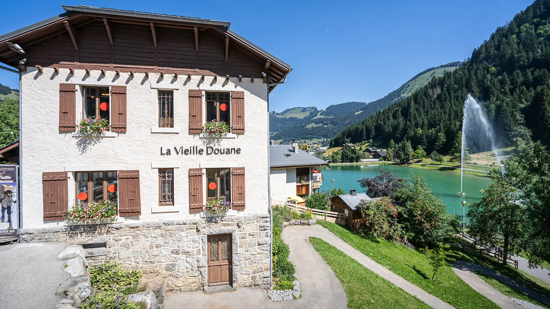 La Vieille Douane en été au bord du Lac de Vonnes et son Jet d'eau et sur la route de Vonnes en direction de la frontière suisse et de Morgins