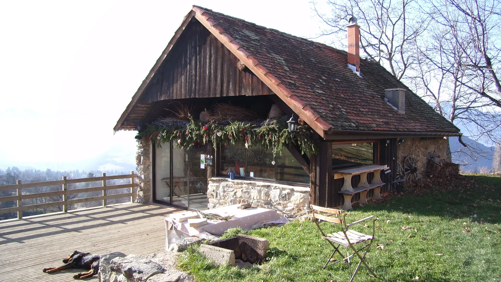 Ferme vue de l'extérieur avec une vue sur la vallée et les montagnes.