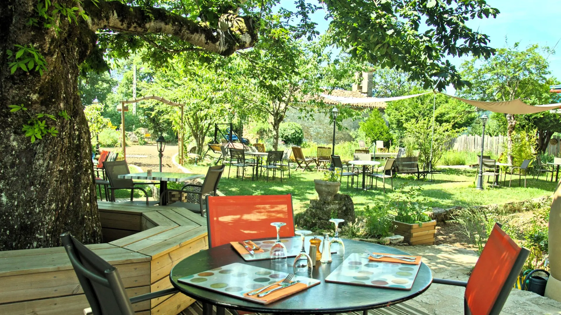 Tables en terrasse dans un jardin ombragé et paisible