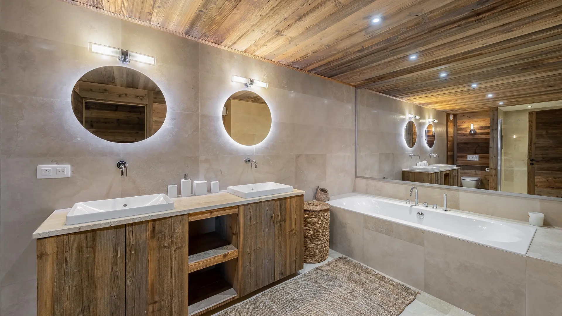 Très grande salle de bains, double vasque avec son meuble en bois,  plafond en bois, grande baignoire