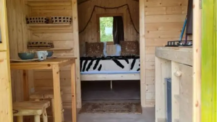 Roulotte de 11m² avec espace nuit et kitchenette : micro-ondes - 2 feux gaz - 1 petit frigo - un évier avec jerricane d'eau pouvant être remplie dans le bloc sanitaire.