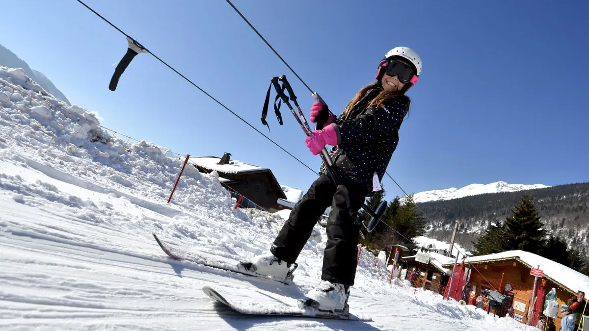 Un skieur remonte en téléski sur le domaine skiable débutants Le Grand-Bornand