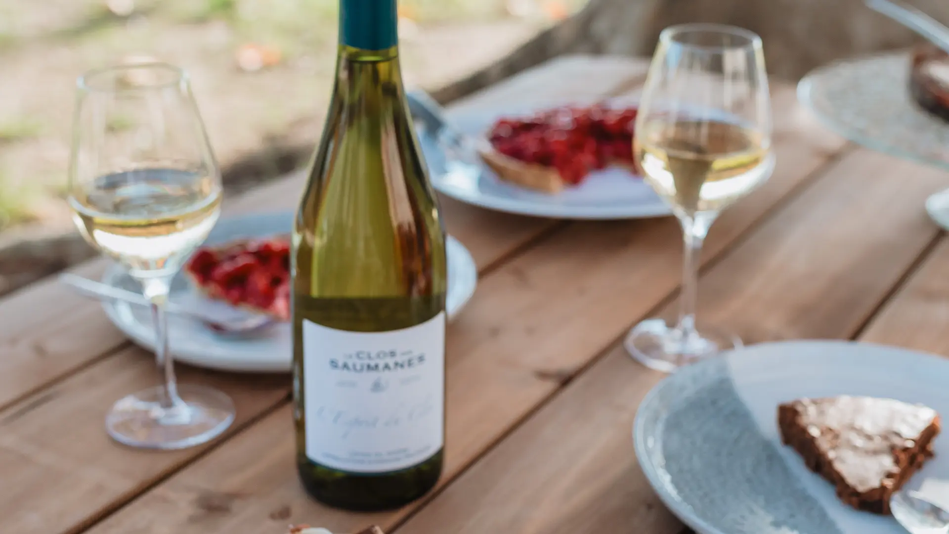 Table au millieu des vignes avec du vin et à manger pour un apéritif.