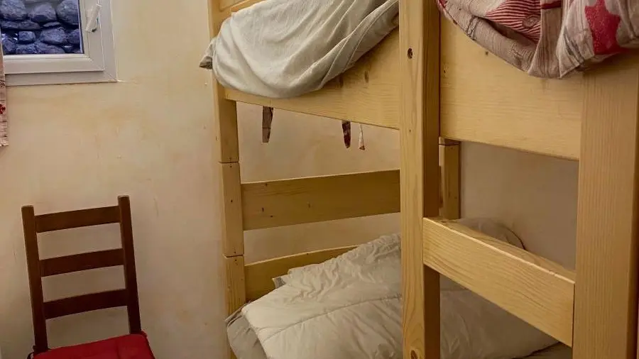 Chambre à coucher carrelée avec lits superposés, fenêtre