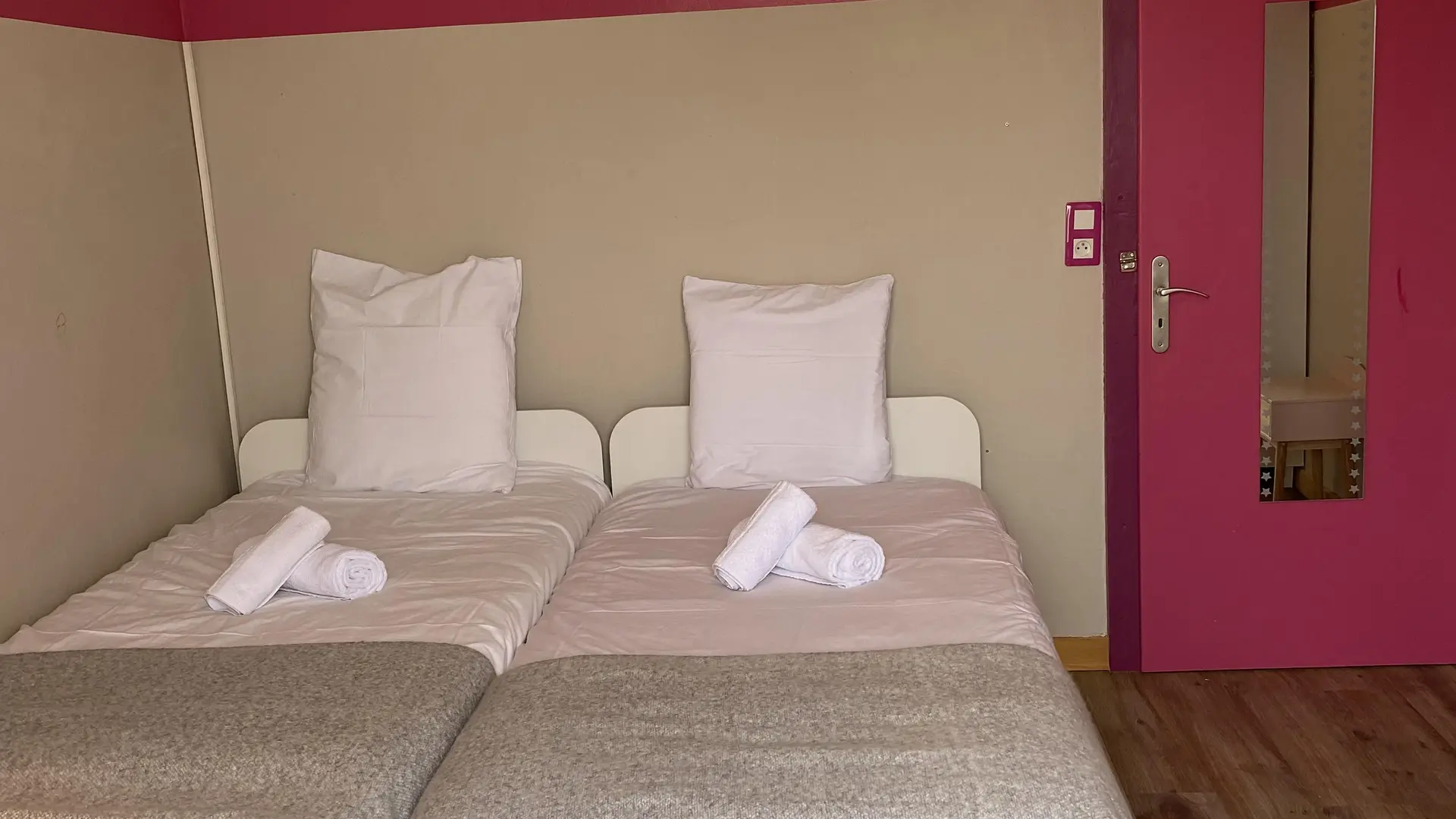 Chambre twin avec deux lits simple, porte rose