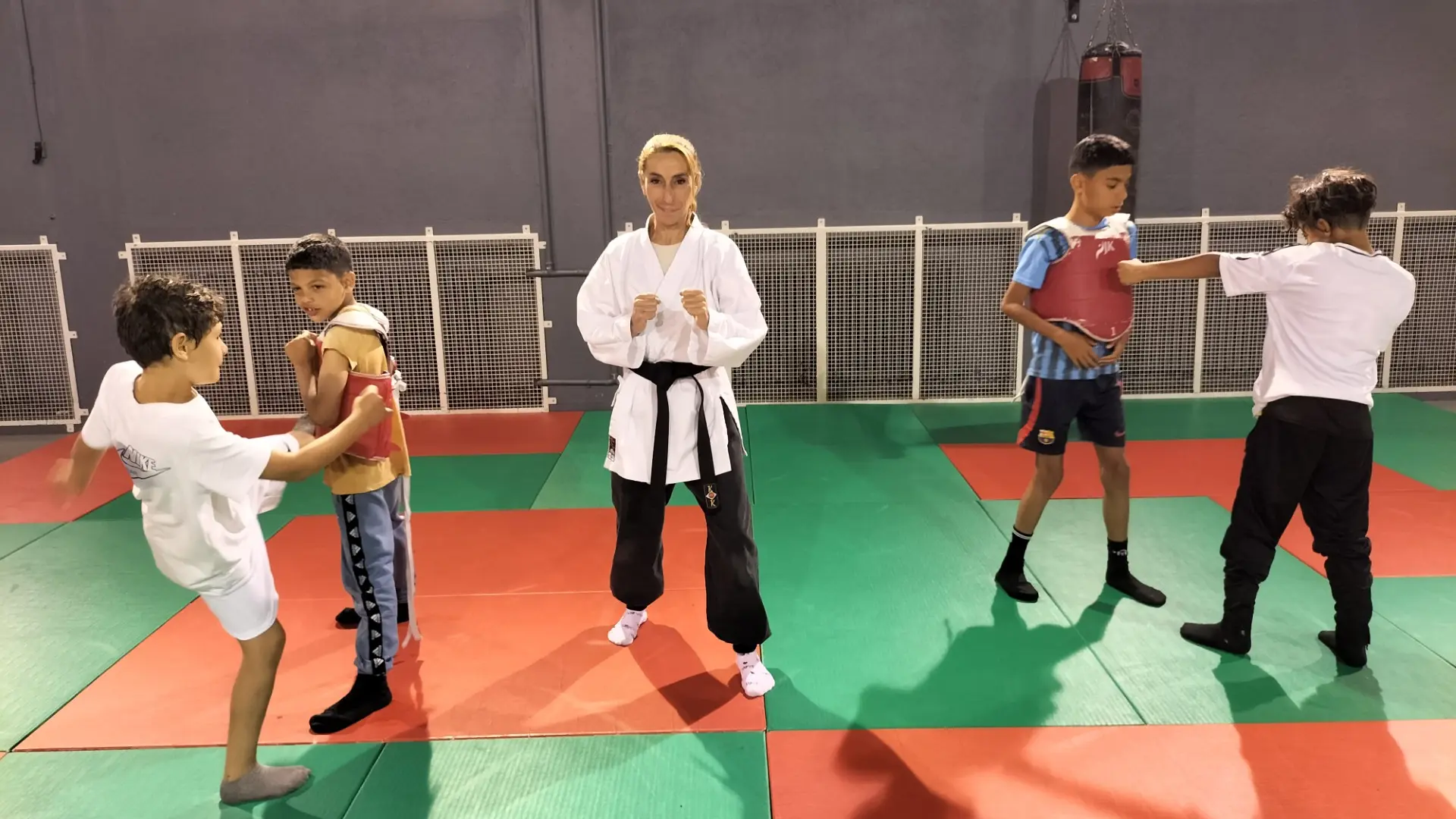 éducateur et groupe de 4 enfants qui s'exercent au sport