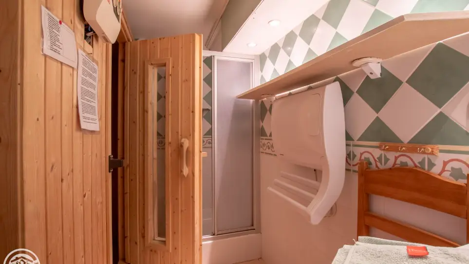 Accès au sauna par la salle de bain. Sèche serviette, douche, lavabo.