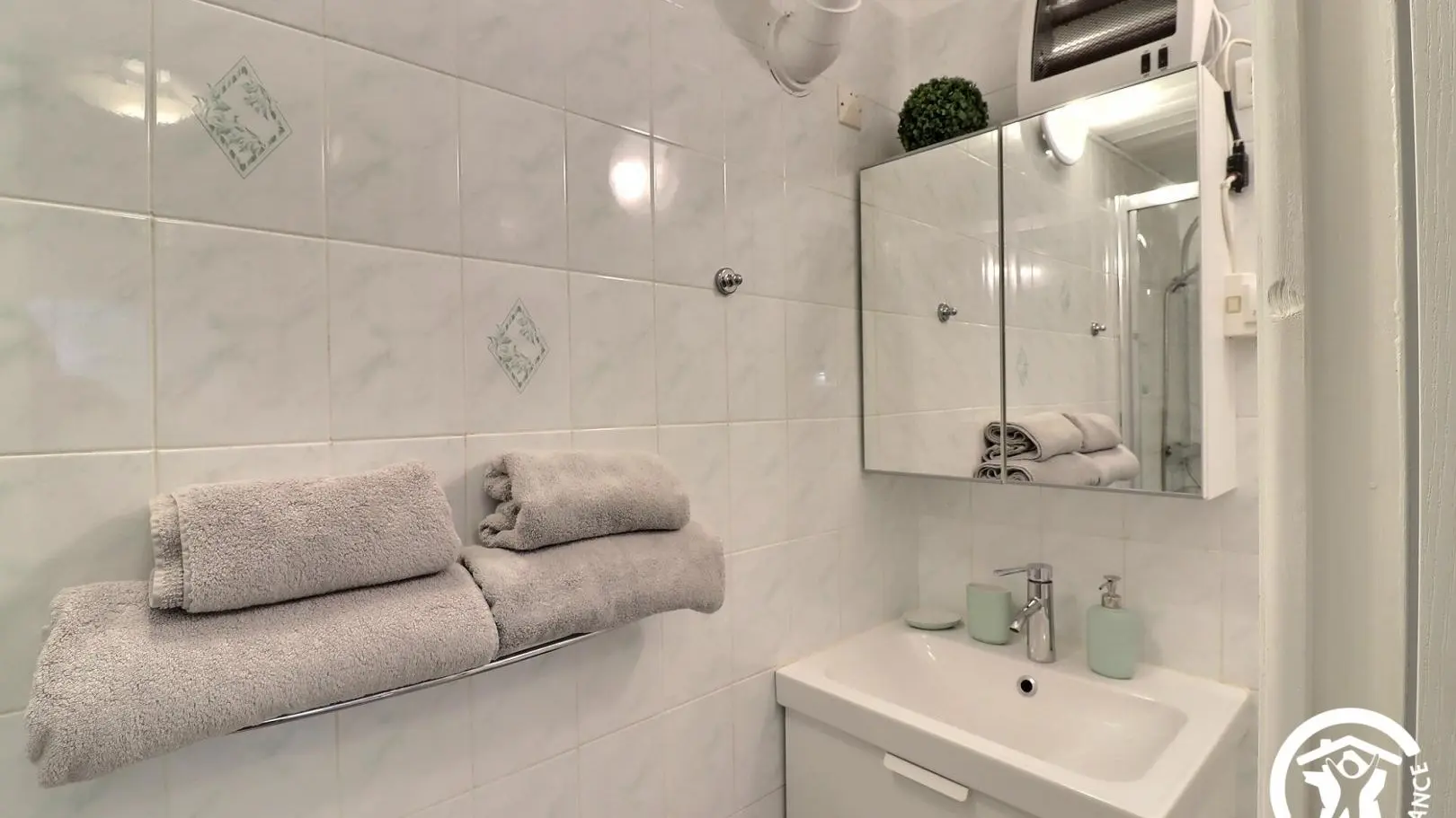 Salle de bain avec un lavabo et un meuble miroir à étagères