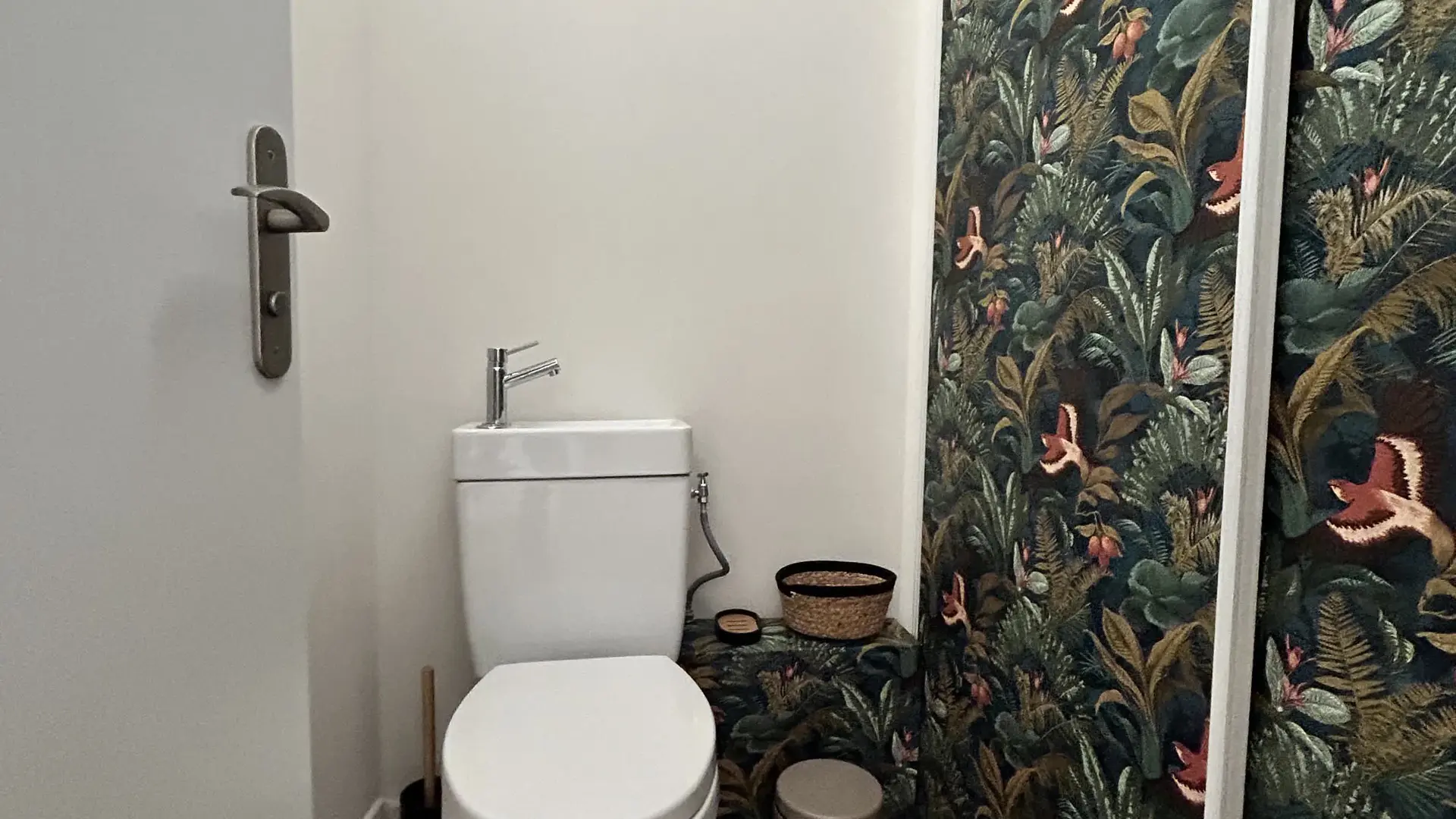 Un espace toilettes original et élégant, sublimé par un papier peint végétal immersif et des finitions naturelles.