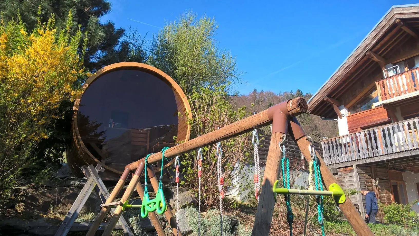 Le jardin avec trampoline, portique et sauna panoramique.
