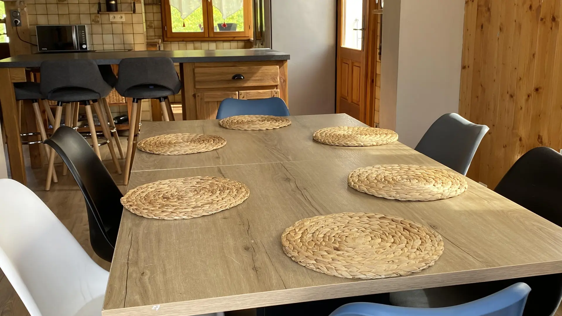 Salle à manger avec en arrière plan la cuisine