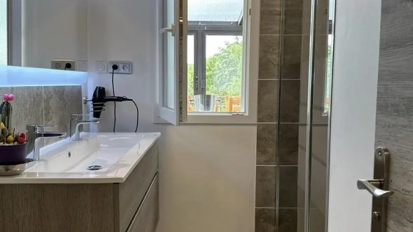 Salle d'eau avec espace lavabo et douche à l'italienne.