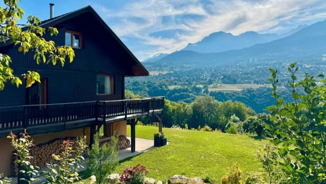 Un chalet en bois avec environnement verdoyant.