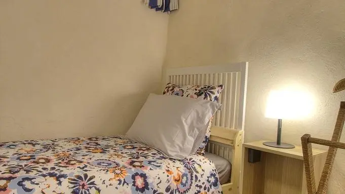 Chambre composée de deux lits simples et d'une petite fenêtre.
