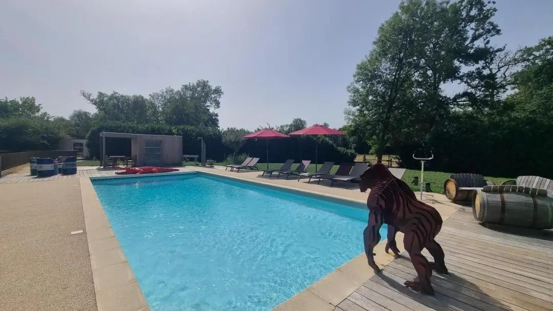 Piscine commune avec les hébergements insolite & le gite : bain de soleil, parasols, salon de jardin, ..