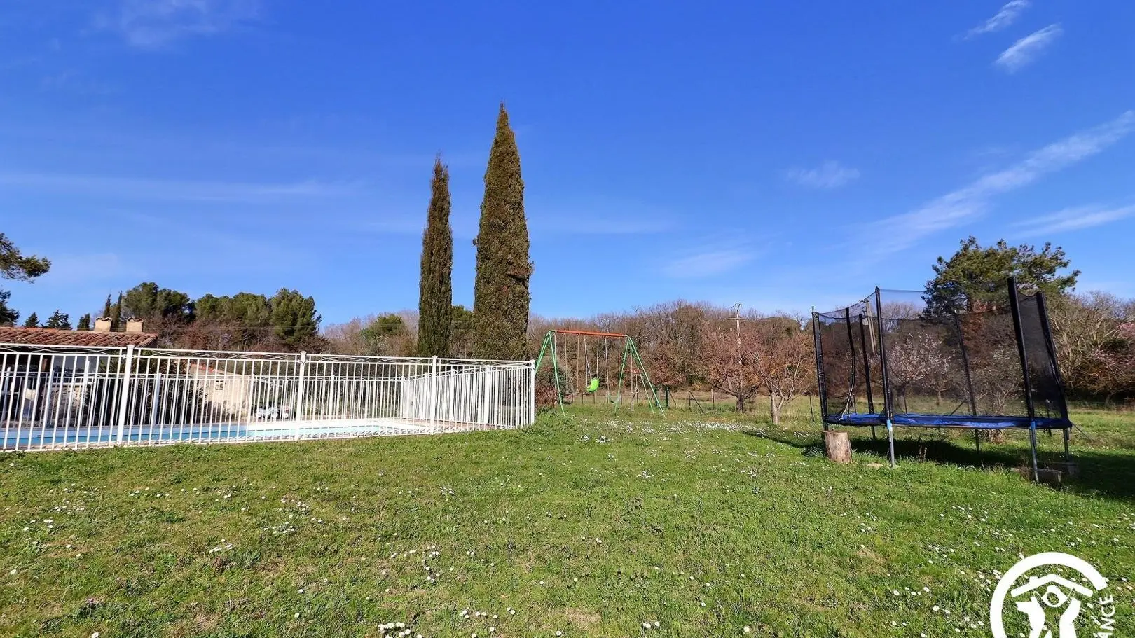 pelouse avec trampoline et portique