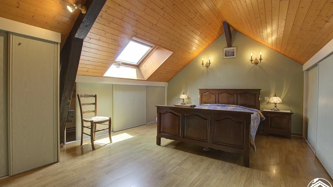 Grande chambre à coucher avec un lit en 140 et un lit pour bébé.