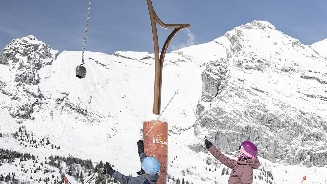 Un enfant accompagné de sa mère sur la piste de la Défi Môm', dédiée aux débutants sur le domaine de ski alpin au Grand-Bornand
