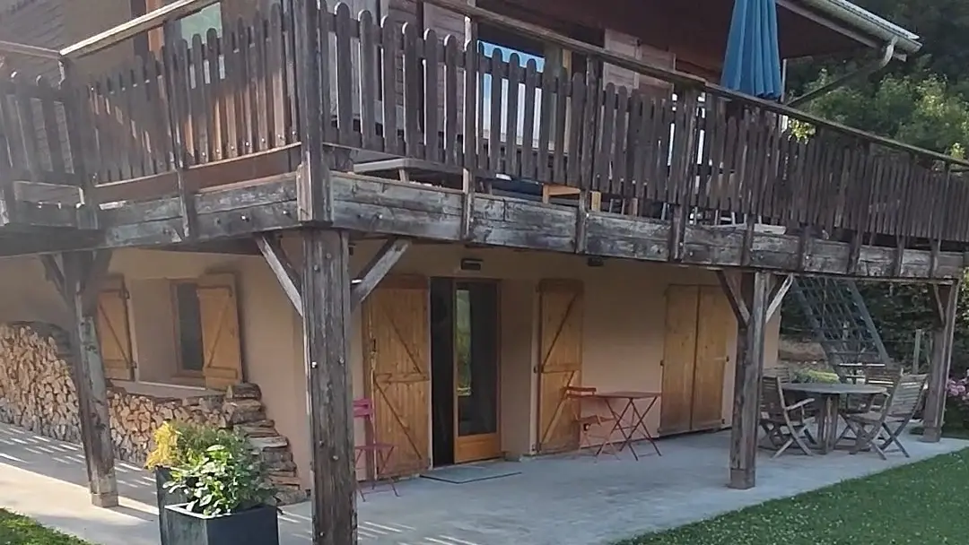 L'entrée de l'appartement situé sous la terrasse en bois du chalet.