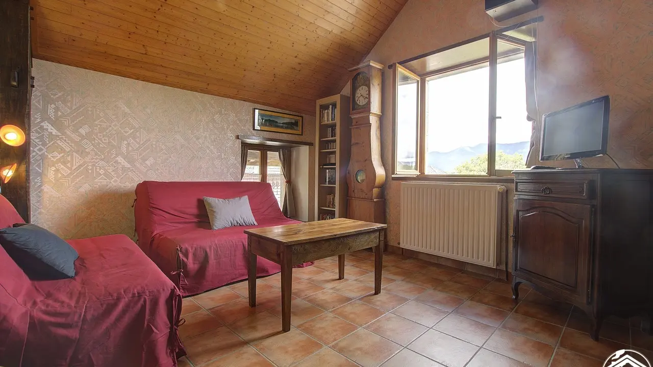 salon avec télévision, lecteur vidéo, chaine hifi. bibliothèque. Vue sur le Grand Colombier.