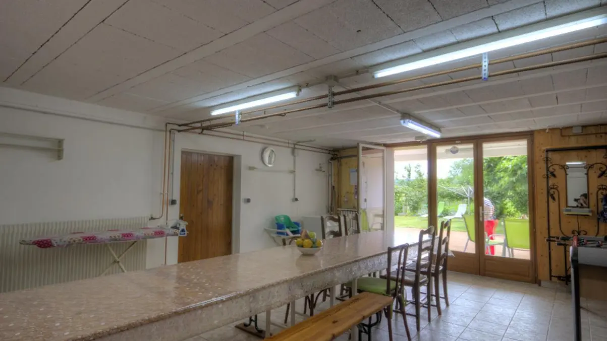 salle avec machine à laver et table à repasser.