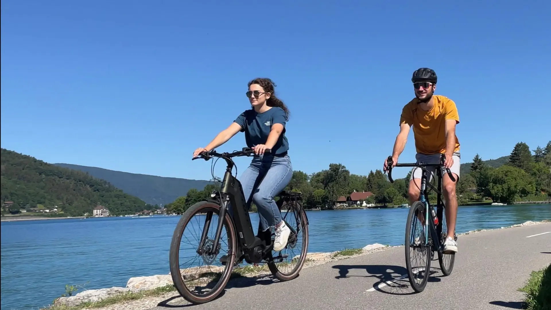 couple cycling by lake Annecy