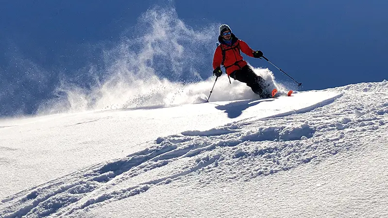 Skieur descendant dans la poudreuse