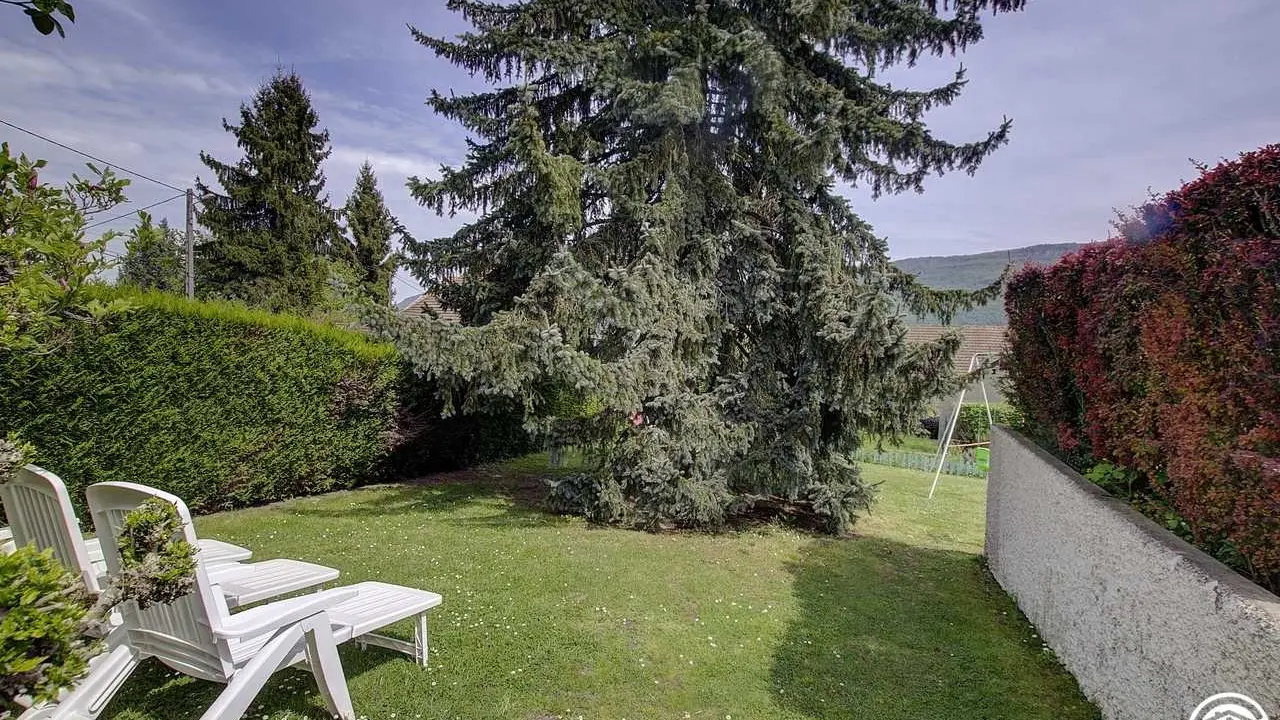 Un jardin agrémenté de jeux de ballons (cage d foot, filet de badminton et panneau de basket)