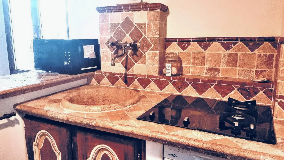 Le carrelage et l'évier de la cuisine en travertin naturel.