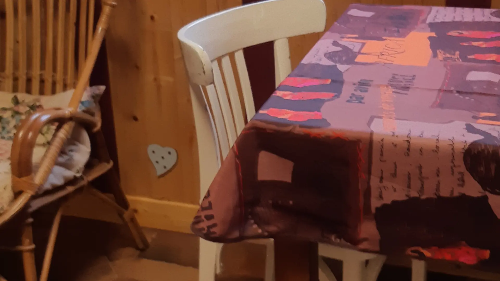 Cette pièce dispose d'un espace repas avec une table et des chaises, ainsi qu'un fauteuil placé près d'une fenêtre.