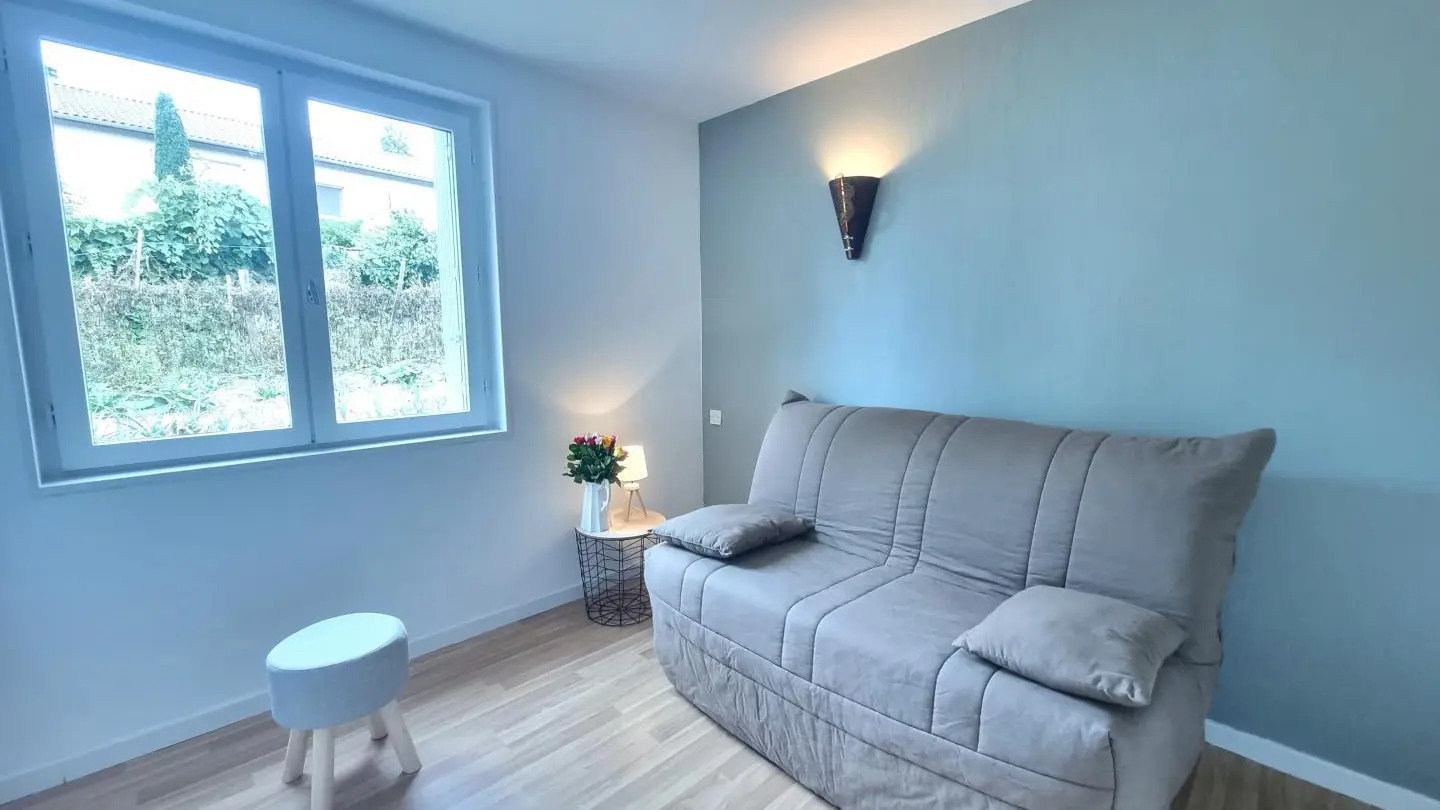 Pièce aménagée en espace salon détente/jeux avec un Bz convertible servant pour un couchage d'appoint.