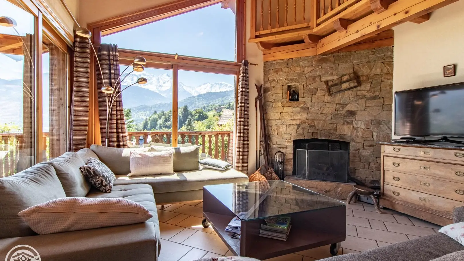 Salon et cheminée en pierres sèches. 2 canapés 3p et 2 fauteuils. Face au Mont-Blanc et aux Fiz.