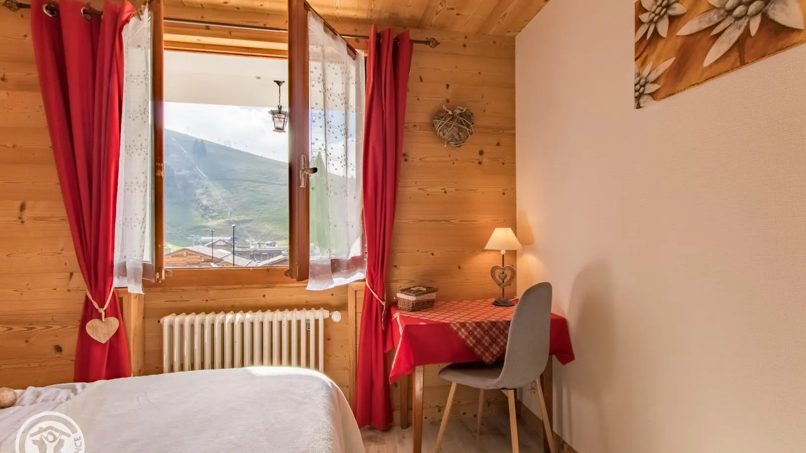 Vue depuis la chambre sur les pistes de ski et les prés verts l'été