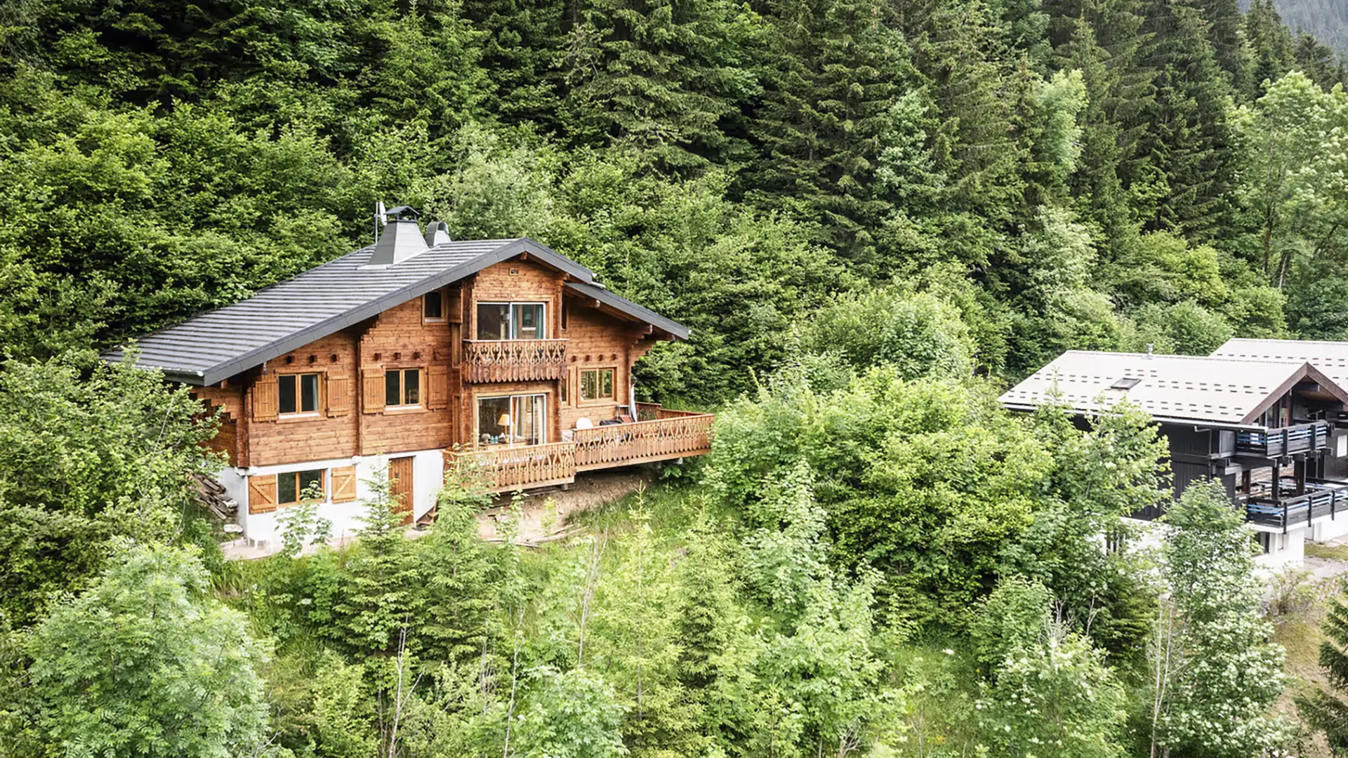 Le chalet en été entouré de verdure