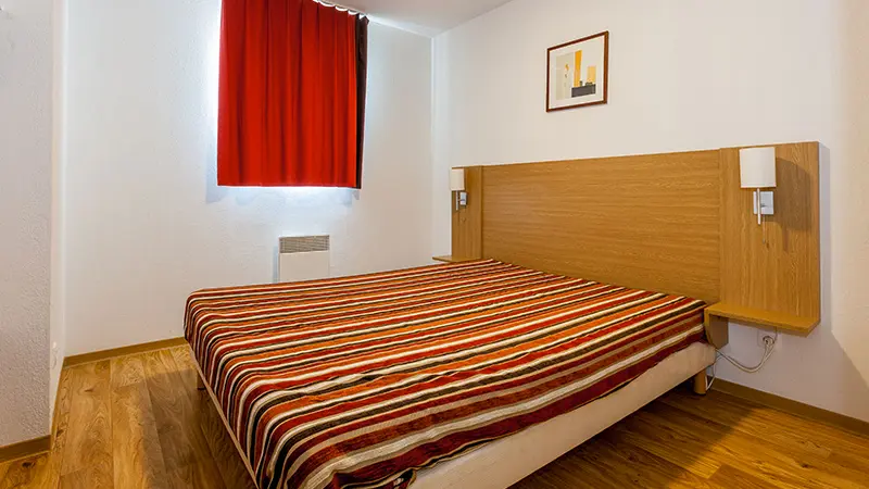 Chambre à coucher avec lit double, fenêtre et rideaux