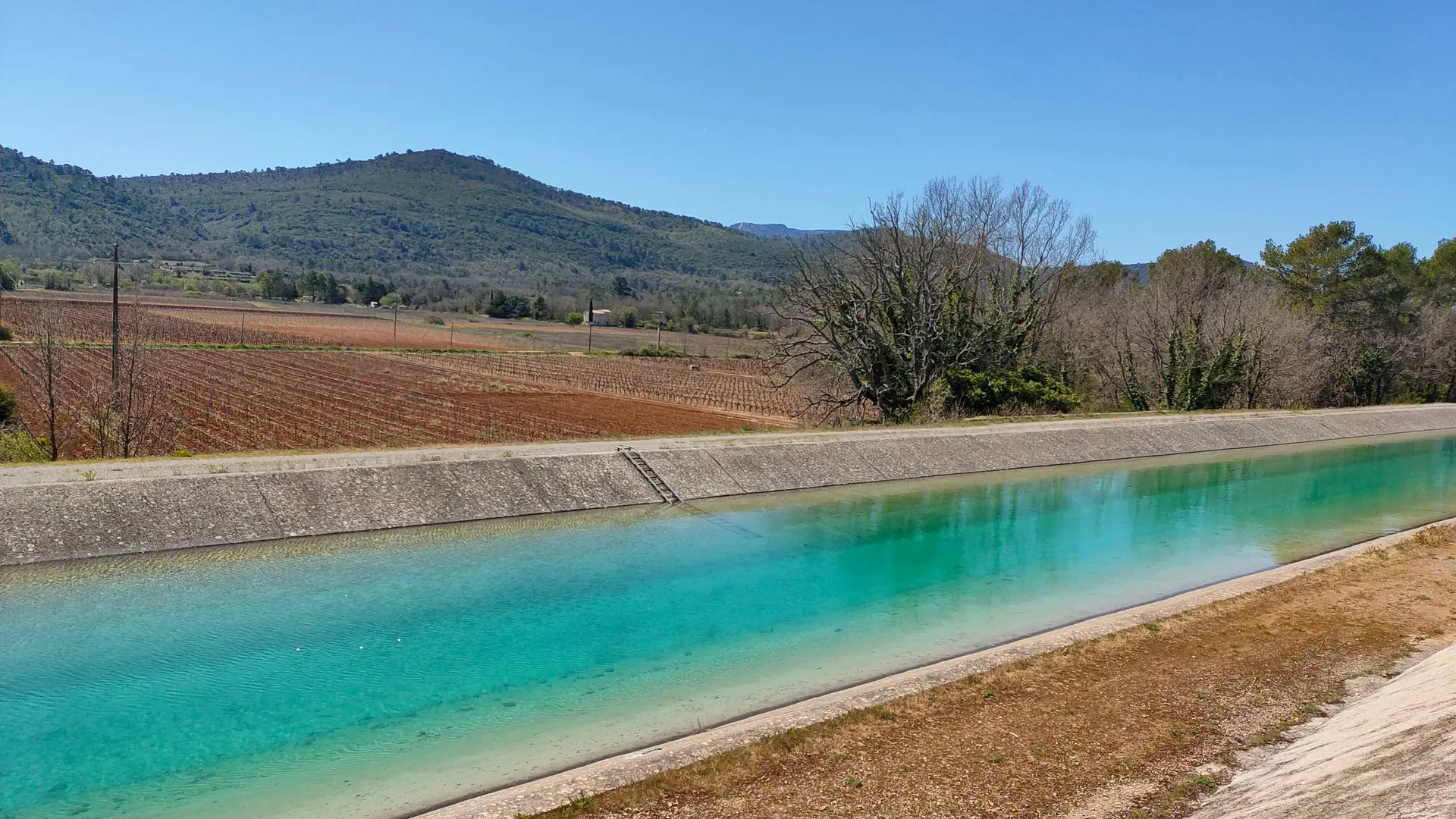 Vue sur l'eau turquoise du canal de Provence, et sur les collines environnantes