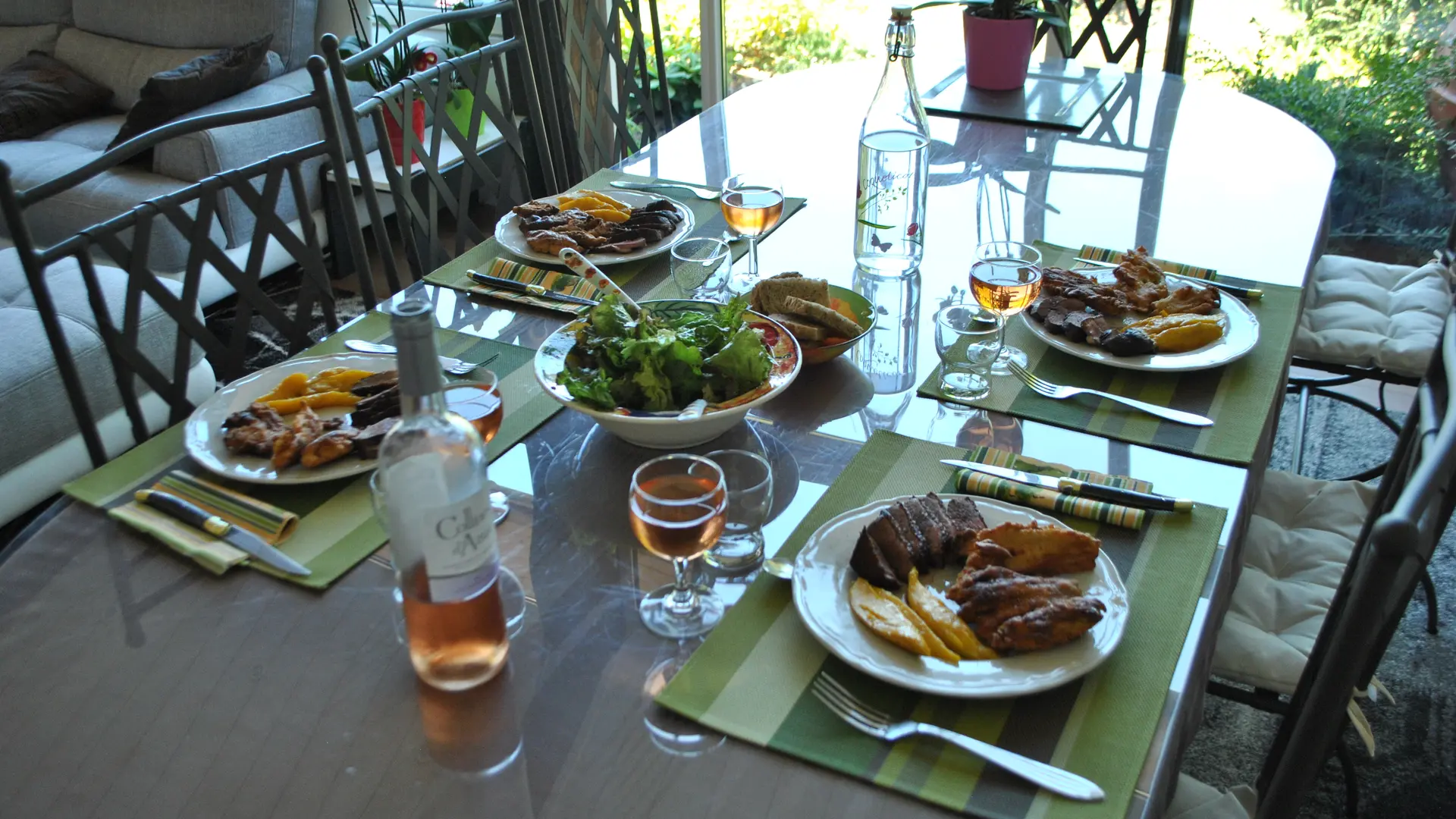 Photo d'une table déjeuner pour 4 avec 4 assiettes de  magret de canard, mangue et beignets de fleurs de courgettes du jardin