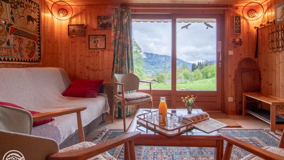 Coin salon, canapé, fauteuil, table basse avec petit déjeuner,  vue sur les montagnes,