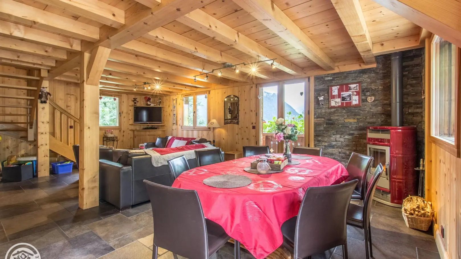 belle pièce a vivre  avec son poêle  a bois poutre apparente grande fenêtre et baie coulissante