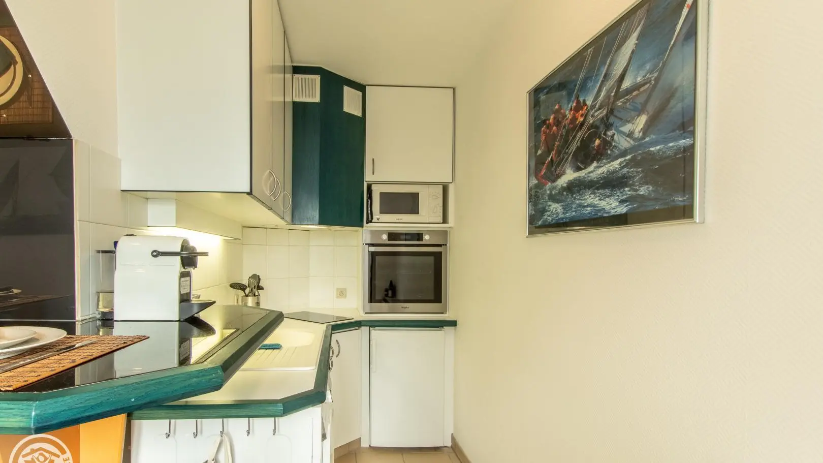 Cuisine intégrée four, réfrigérateur (partie congélation), hotte, plaque à induction, micro ondes, cafetière à dosettes + cafetière filtres, bouilloire, grille pain